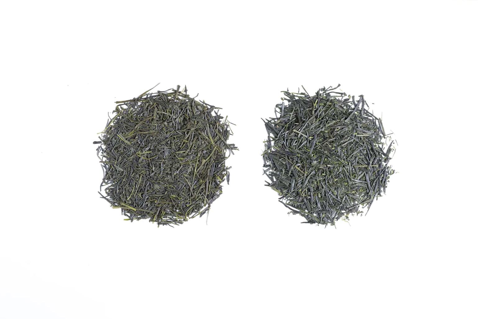 Two higher grade sencha piles compared side by side: about 2,000 yen and 3,000 to 3,500 yen per 100 grams, from left to right