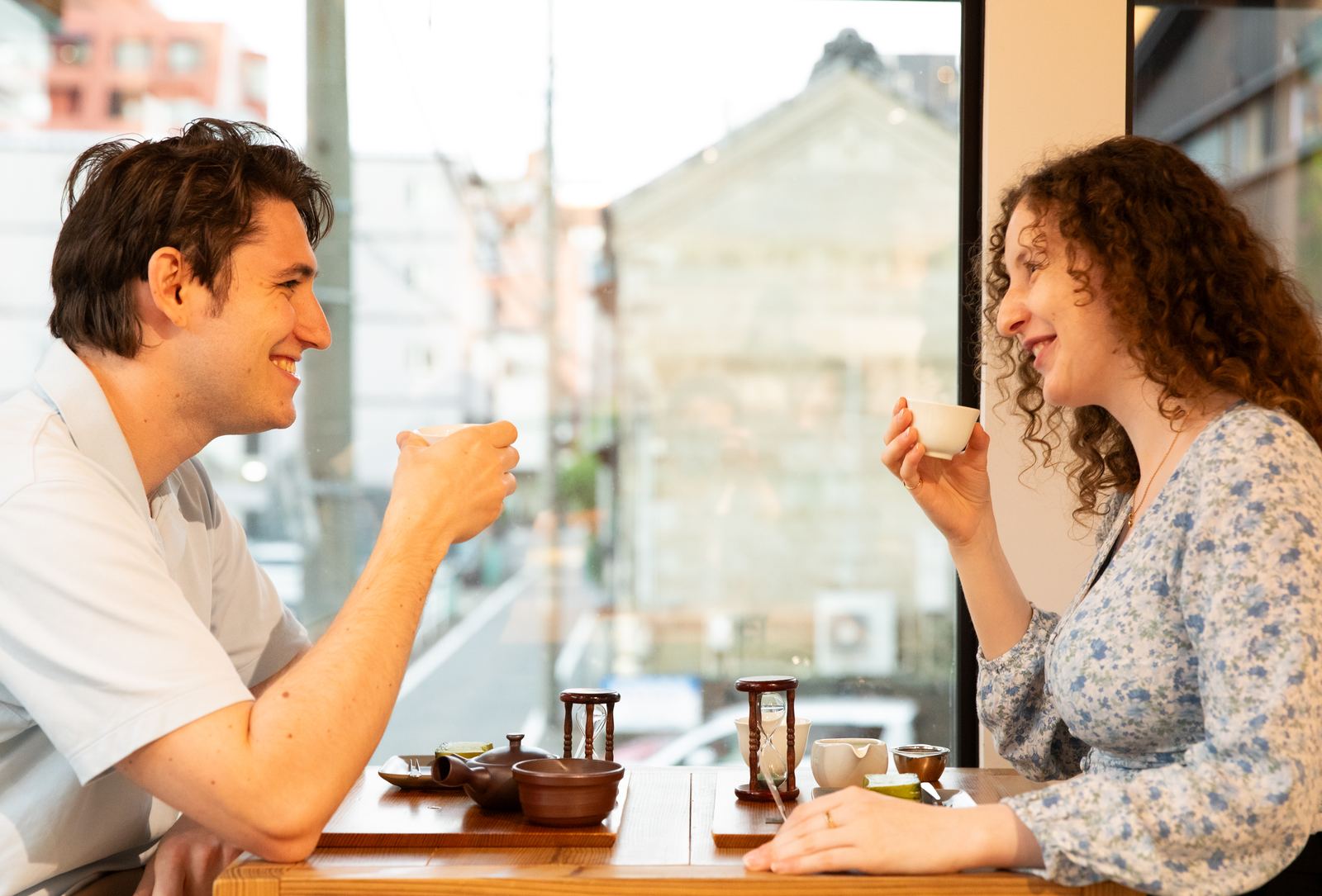 Two overseas guests comparing teas at the mirume cafe, with a kyusu teapot and sand timers on the table